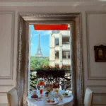 Breakfast served on a classic Parisian balcony with red awnings and an Eiffel Tower view