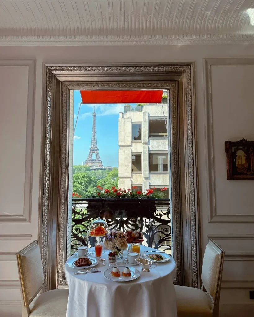 Breakfast served on a classic Parisian balcony with red awnings and an Eiffel Tower view