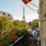 Flower-filled terrace with red awnings and views of the Eiffel Tower at Hôtel Plaza Athénée Paris