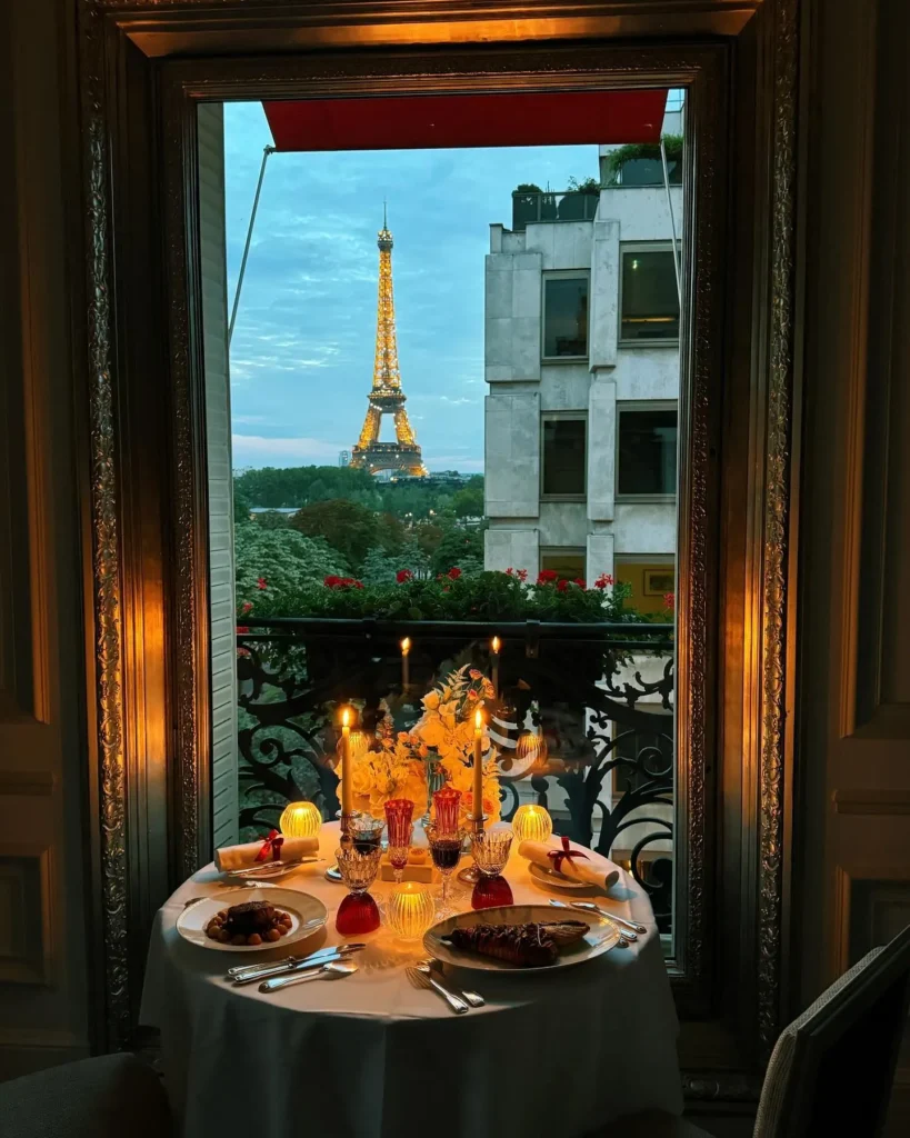 Romantic evening dining setup beside a window with Paris views at Hôtel Plaza Athénée