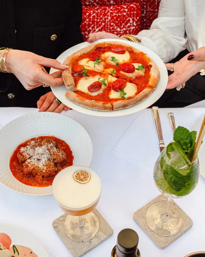 Gourmet dishes and drinks arranged on an elegant restaurant table at Hôtel Plaza Athénée Paris