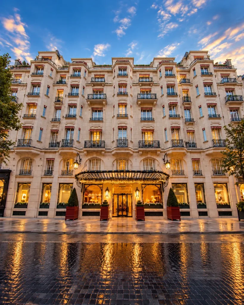 Elegant exterior facade of Hôtel Plaza Athénée Paris beneath a colorful evening sky