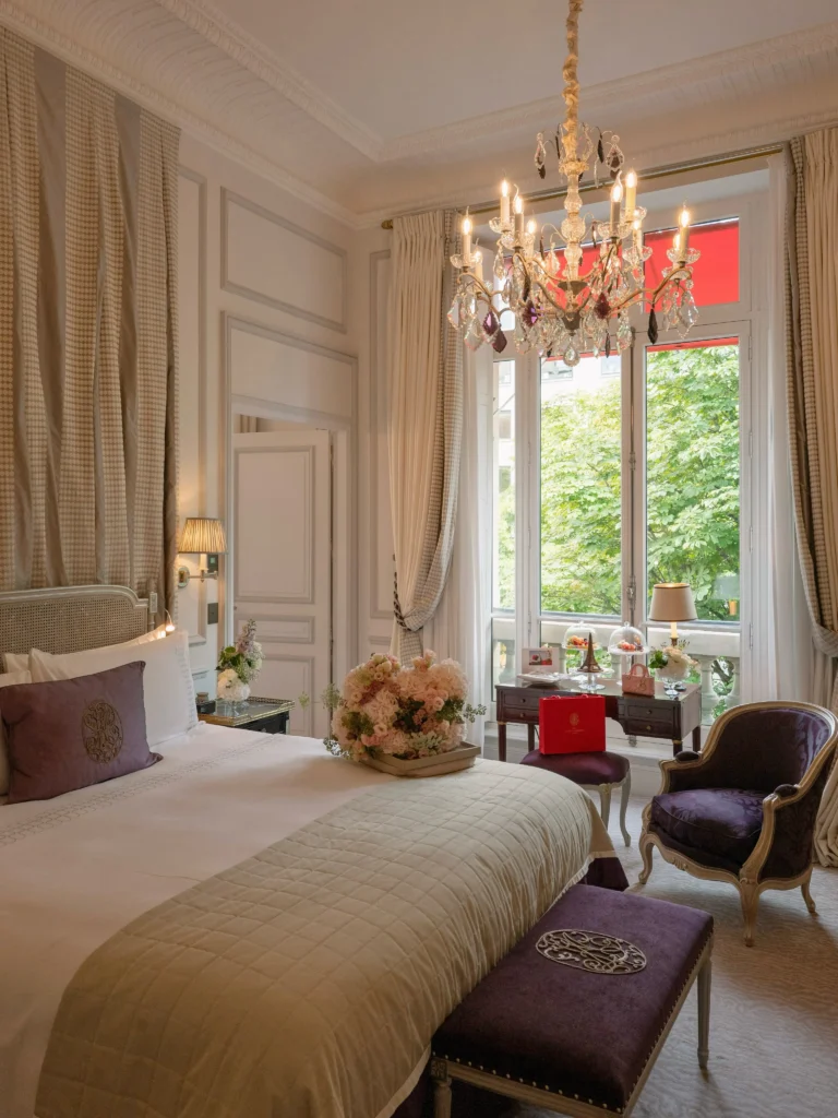 Elegant hotel suite with a refined bedroom, soft neutral colors and classic Parisian furnishings