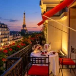 Romantic balcony with red awnings and a glowing Paris skyline at dusk