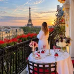 Romantic outdoor dining on a Paris balcony at sunset with flowers and views of the Eiffel Tower