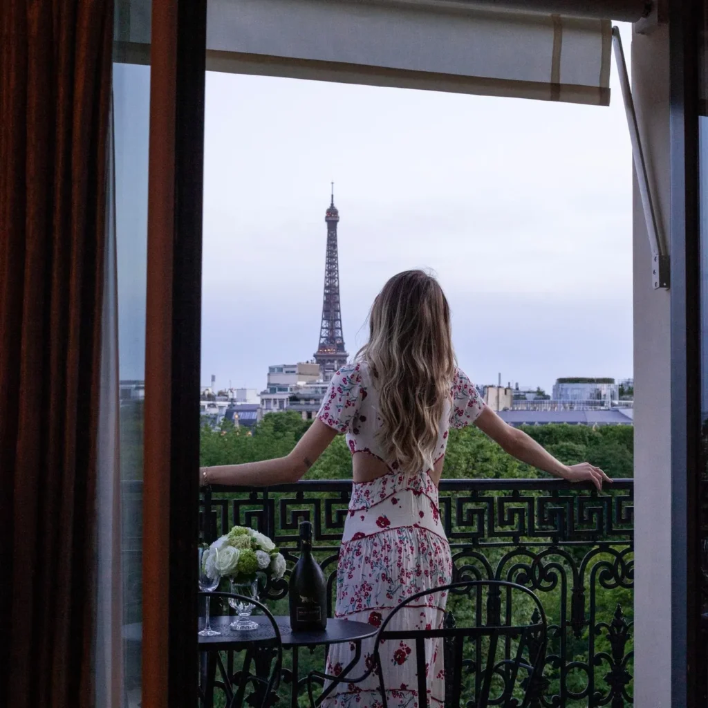 Guest standing on a private balcony overlooking Paris at La Réserve Paris
