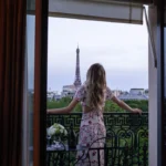 Guest standing on a private balcony overlooking Paris at La Réserve Paris