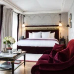 Classic hotel suite with burgundy armchairs and refined French furnishings at La Réserve Paris