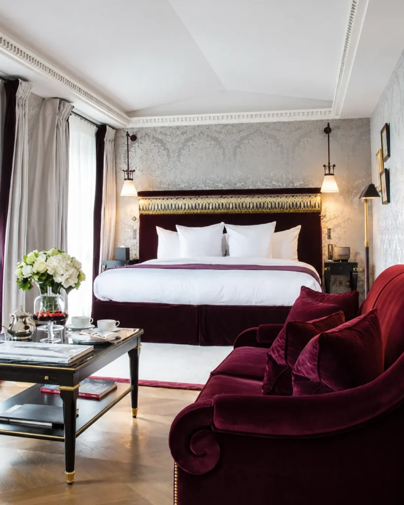 Classic hotel suite with burgundy armchairs and refined French furnishings at La Réserve Paris