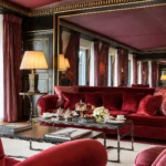 Opulent salon with burgundy velvet sofas, classic furnishings and warm lighting at La Réserve Paris