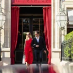 Elegant entrance to La Réserve Paris with a red doorway and classic stone facade