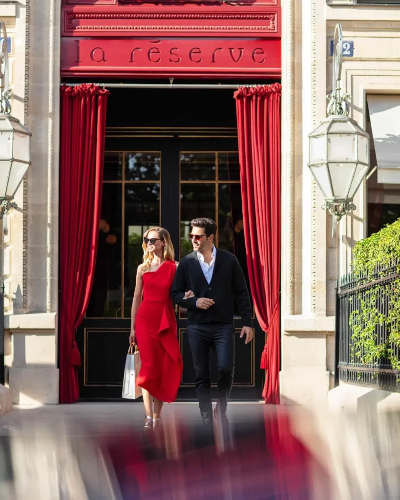 Elegant entrance to La Réserve Paris with a red doorway and classic stone facade