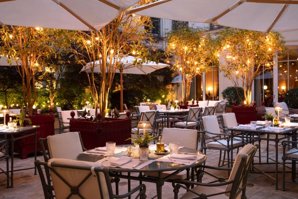Elegant outdoor dining terrace illuminated by warm lights at La Réserve Paris