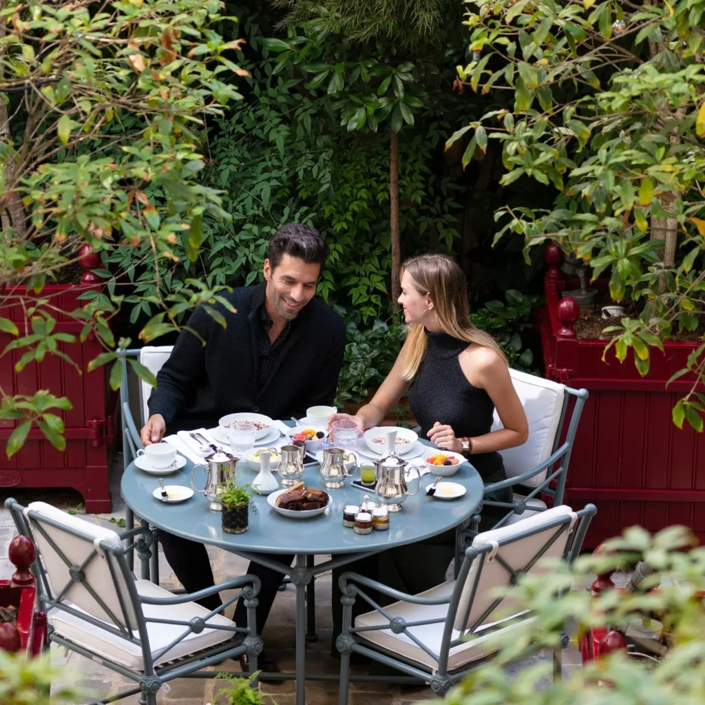 Outdoor terrace table surrounded by lush greenery at La Réserve Paris