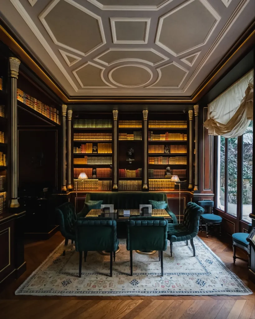 Elegant wood-panelled library lounge with bookshelves and refined seating at La Réserve Paris