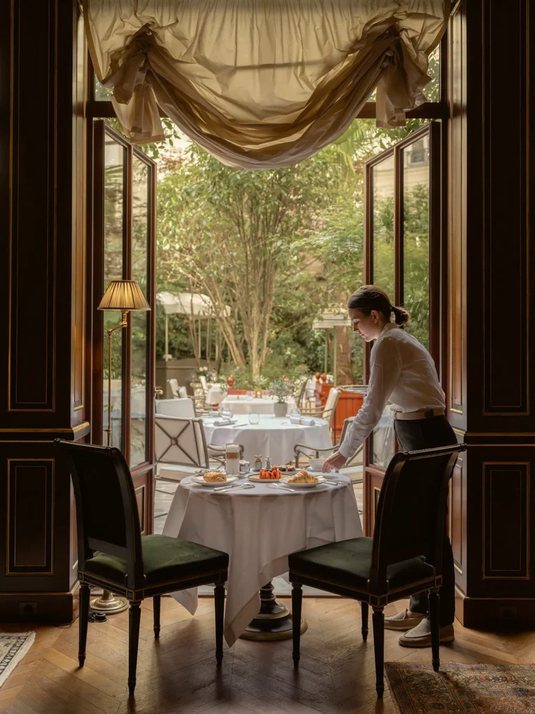 Private dining table beside tall windows in an elegant room at La Réserve Paris