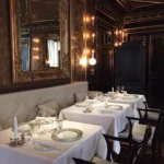Intimate dining room with elegant table settings and dark wood interiors at La Réserve Paris
