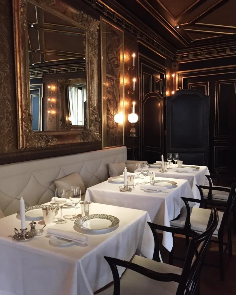 Intimate dining room with elegant table settings and dark wood interiors at La Réserve Paris
