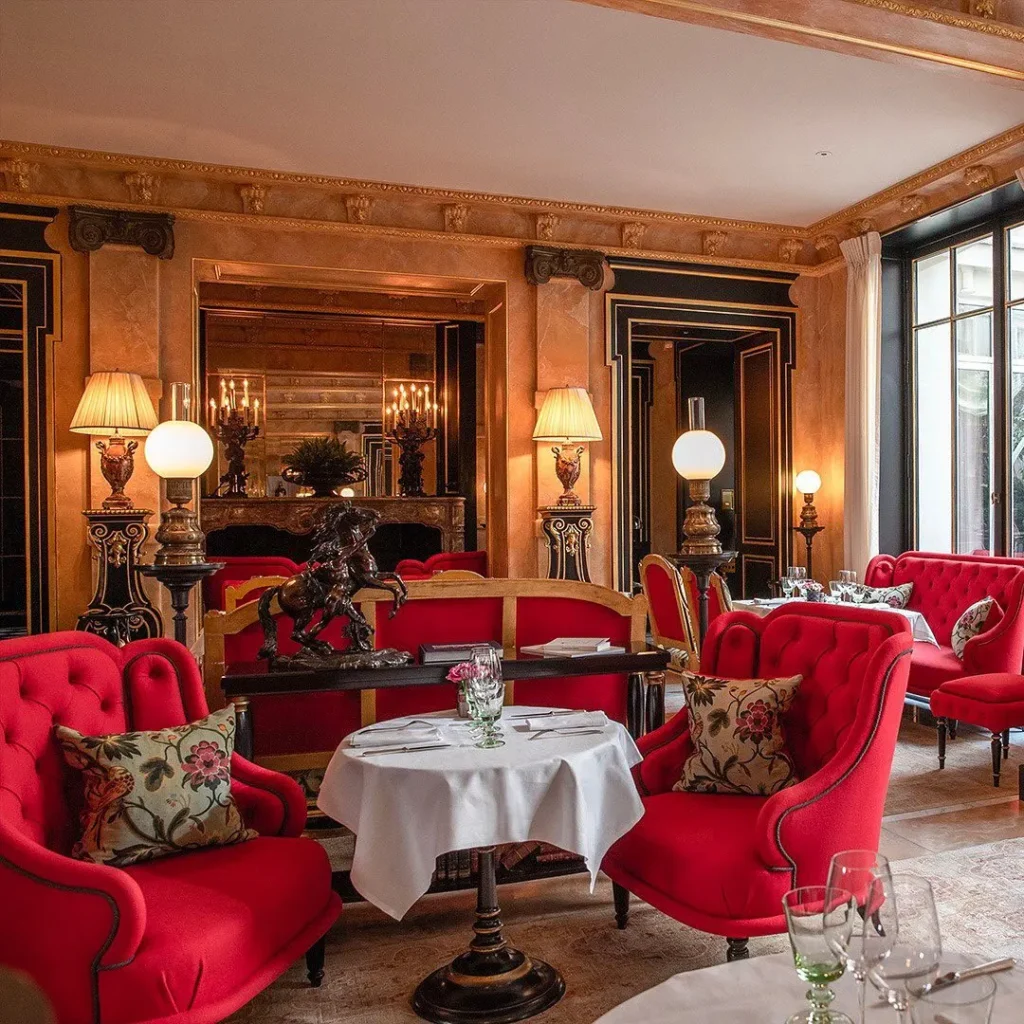 Elegant restaurant dining room with red velvet chairs and classic interiors at La Réserve Paris