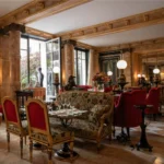 Classic restaurant interior with red chairs, elegant table settings and warm lighting at La Réserve Paris