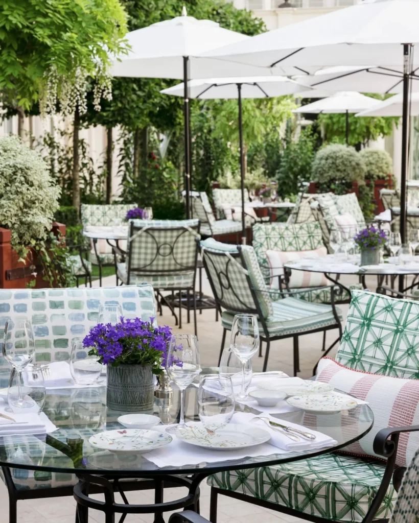 Outdoor restaurant tables surrounded by greenery at Le Bristol Paris