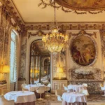 Fine dining room at Le Meurice Paris with ornate walls and elegant tables