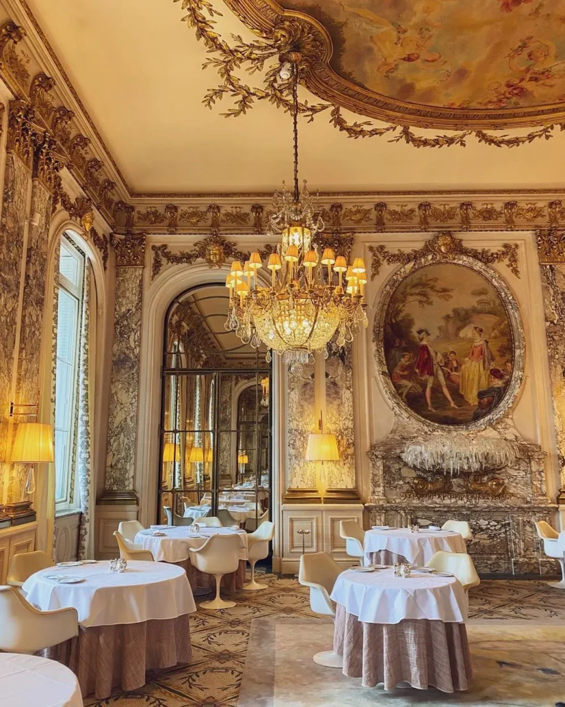 Fine dining room at Le Meurice Paris with ornate walls and elegant tables