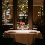 Intimate fine dining table with white linens, elegant glassware and warm ambient lighting at Mandarin Oriental Milan