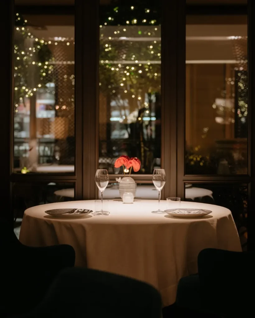Intimate fine dining table with white linens, elegant glassware and warm ambient lighting at Mandarin Oriental Milan
