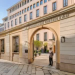 Historic cream-colored facade and arched entrance of Mandarin Oriental Milan on a cobblestone street