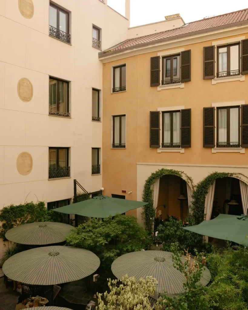 Quiet inner courtyard surrounded by historic hotel buildings with landscaped greenery and outdoor seating at Mandarin Oriental Milan