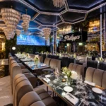 Philipp's elegant restaurant interior featuring geometric ceiling lights, crystal chandeliers, mirrored walls, marble dining tables, and plush velvet seating.