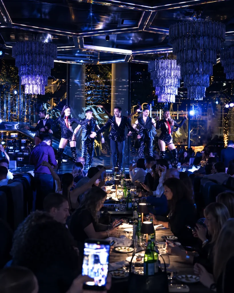 Blue-lit dinner show with live entertainment and guests dining at Philipp's Club Milano