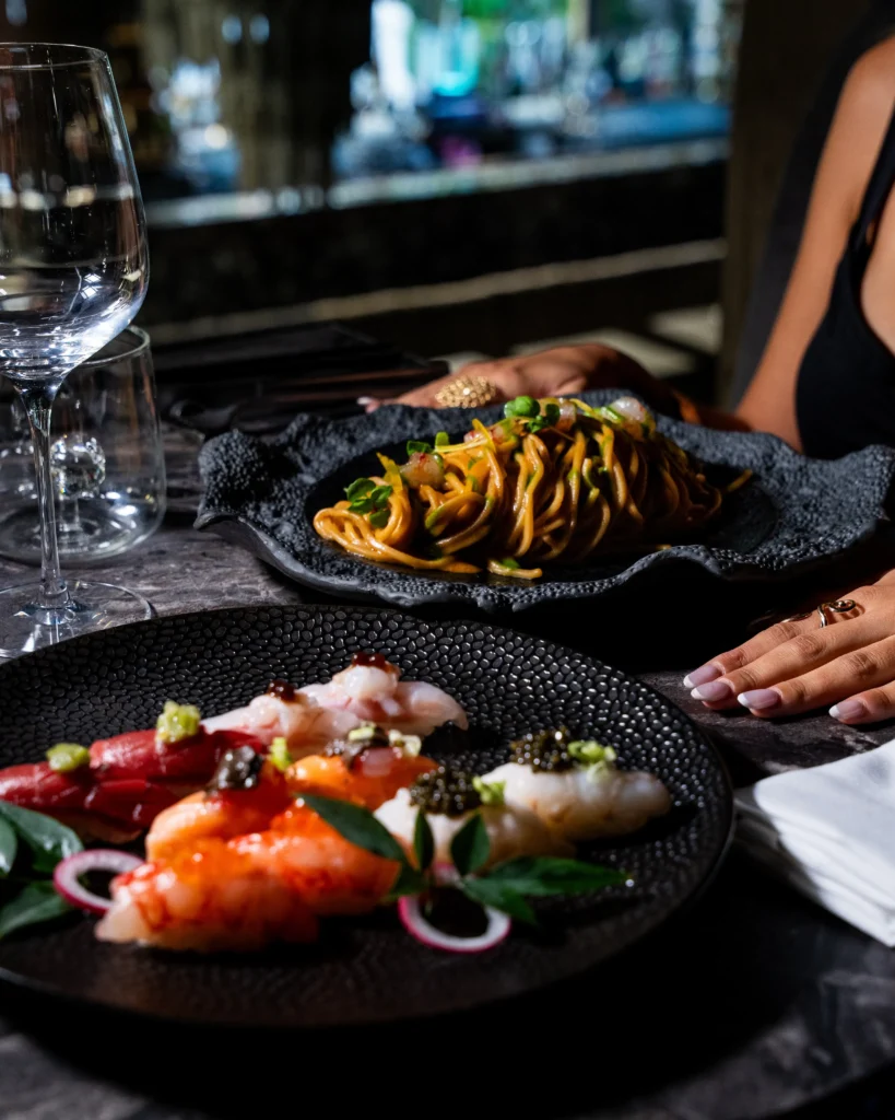 Gourmet pasta dish served alongside other plated dishes at Philipp's Club Milano