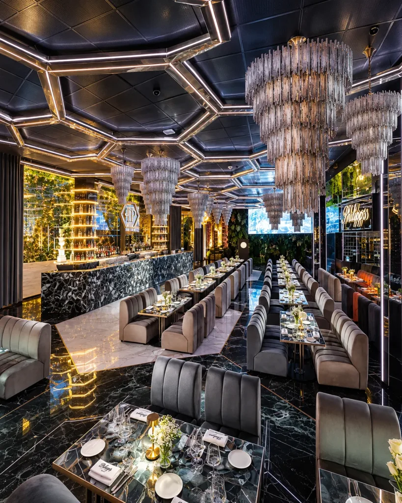 Contemporary dining lounge with illuminated hexagonal ceiling panels, plush seating and elegant tables at Philipp's Club Milano