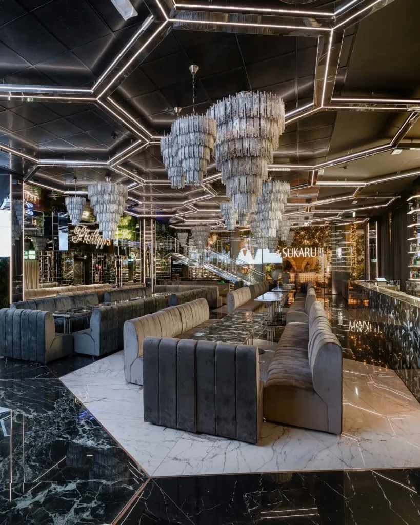 Luxury dining lounge with plush seating, sculptural ceiling lights and sophisticated decor at Philipp's Club Milano