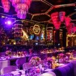 Colorful nightclub dining lounge with purple neon lights, decorative chandeliers and elegant seating at Philipp's Club Milano