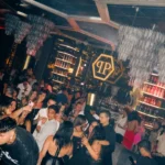 Guests enjoying the lively nightclub atmosphere beneath geometric ceiling lights at Philipp's Club Milano