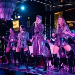 Live performers on stage under vibrant purple and blue lighting at Philipp's Club Milano