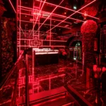 Red neon lighting and decorative floral elements inside Philipp's Club Milano