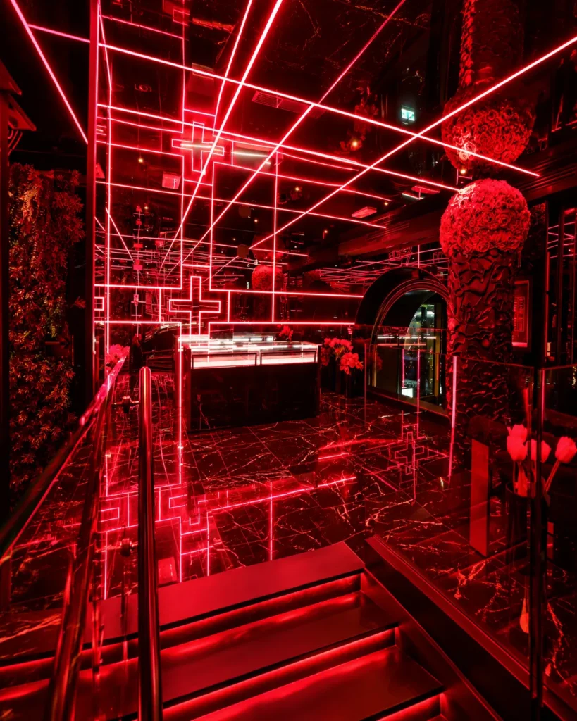 Red neon lighting and decorative floral elements inside Philipp's Club Milano