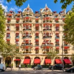 Hôtel Plaza Athénée Paris luxury hotel exterior with red awnings, flower-filled balconies and classic French architecture