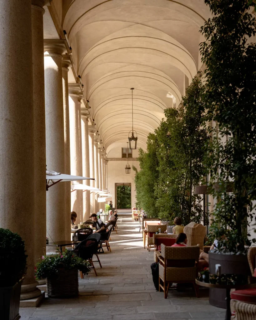 Elegant outdoor dining tables beneath the historic vaulted colonnades at Portrait Milano