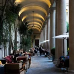 Elegant outdoor dining area beneath the historic arched colonnades of Portrait Milano