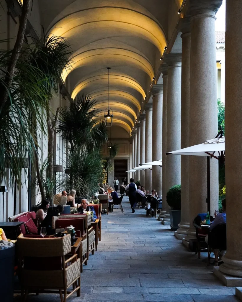 Elegant outdoor dining area beneath the historic arched colonnades of Portrait Milano