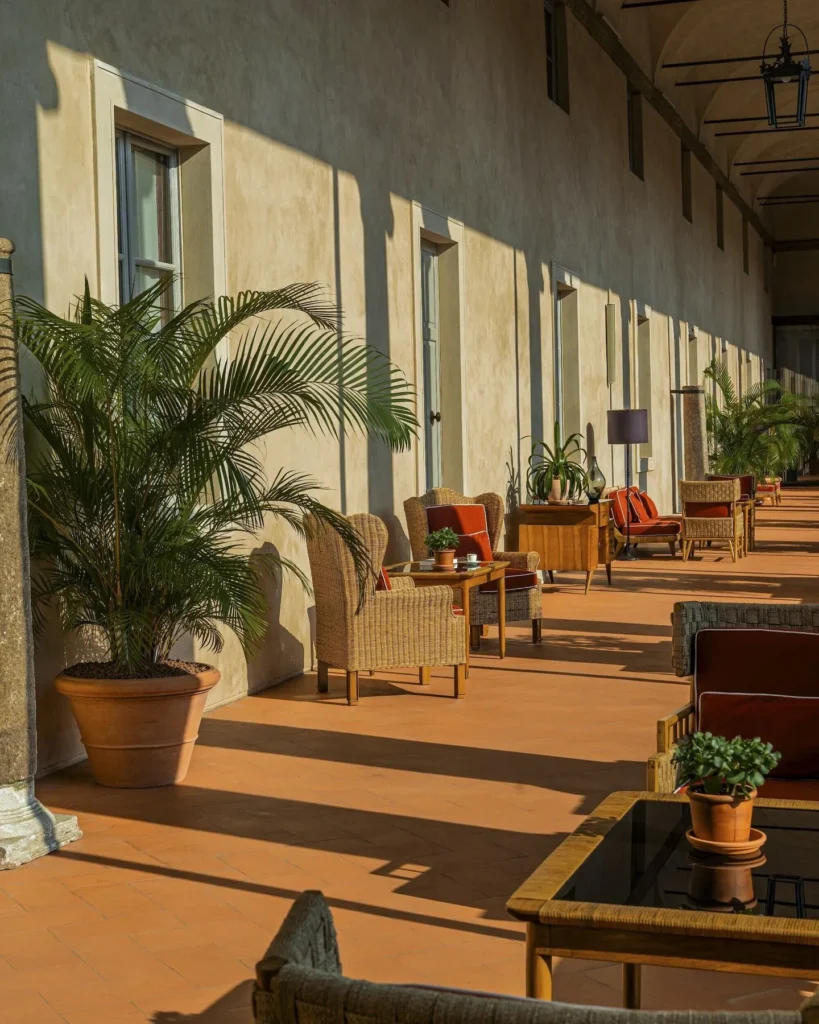 Relaxed outdoor lounge area with wooden flooring, comfortable seating and potted plants at Portrait Milano