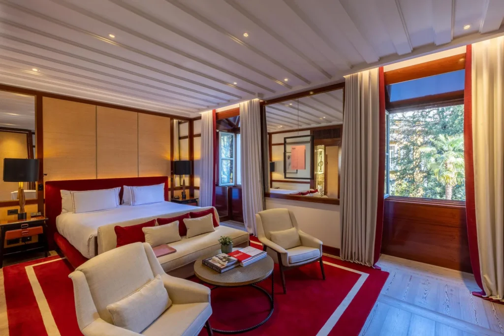 Garden studio deluxe suite at Portrait Milano featuring a comfortable lounge, contemporary furnishings and large windows overlooking greenery
