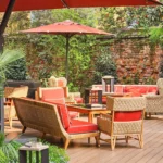 Outdoor lounge terrace with red parasols, comfortable seating and lush greenery at Portrait Milano