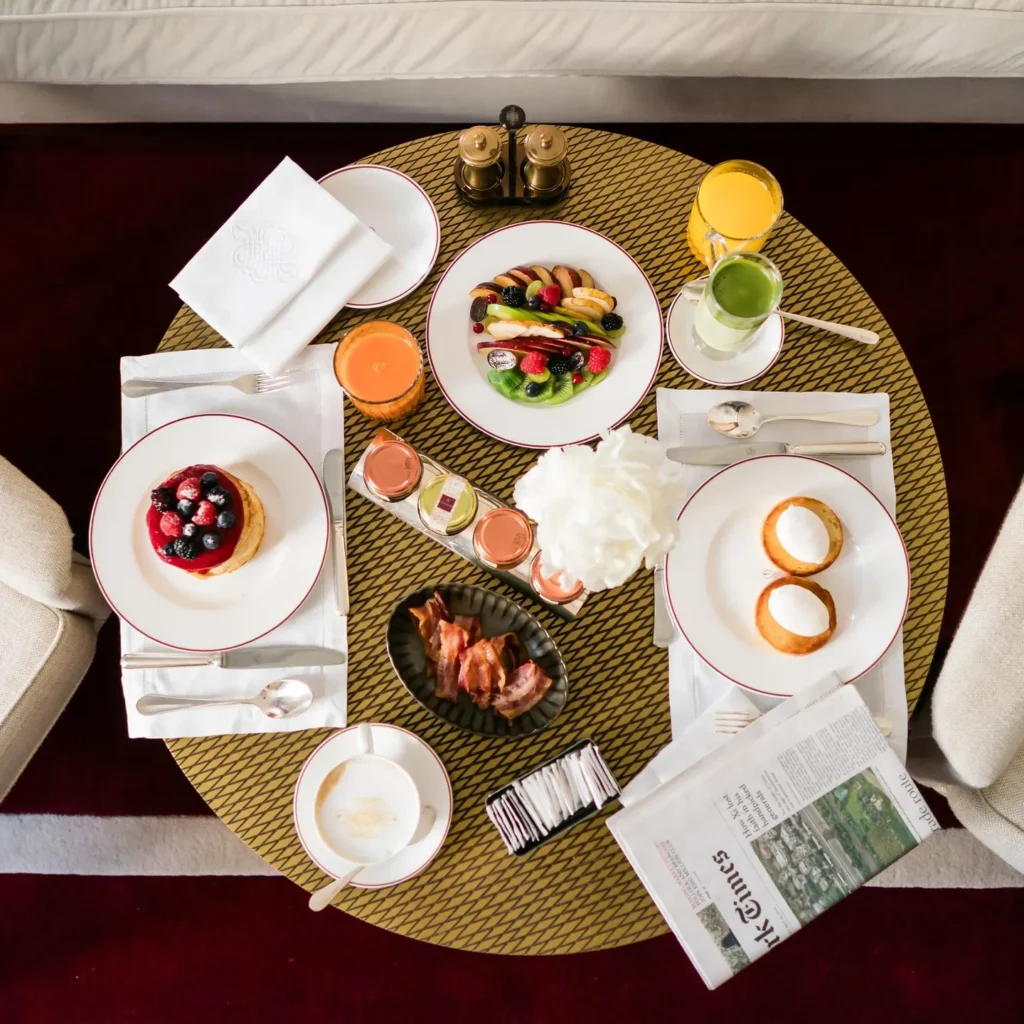 Breakfast spread with pastries, fresh fruit, coffee and plated dishes arranged on a table at Portrait Milano