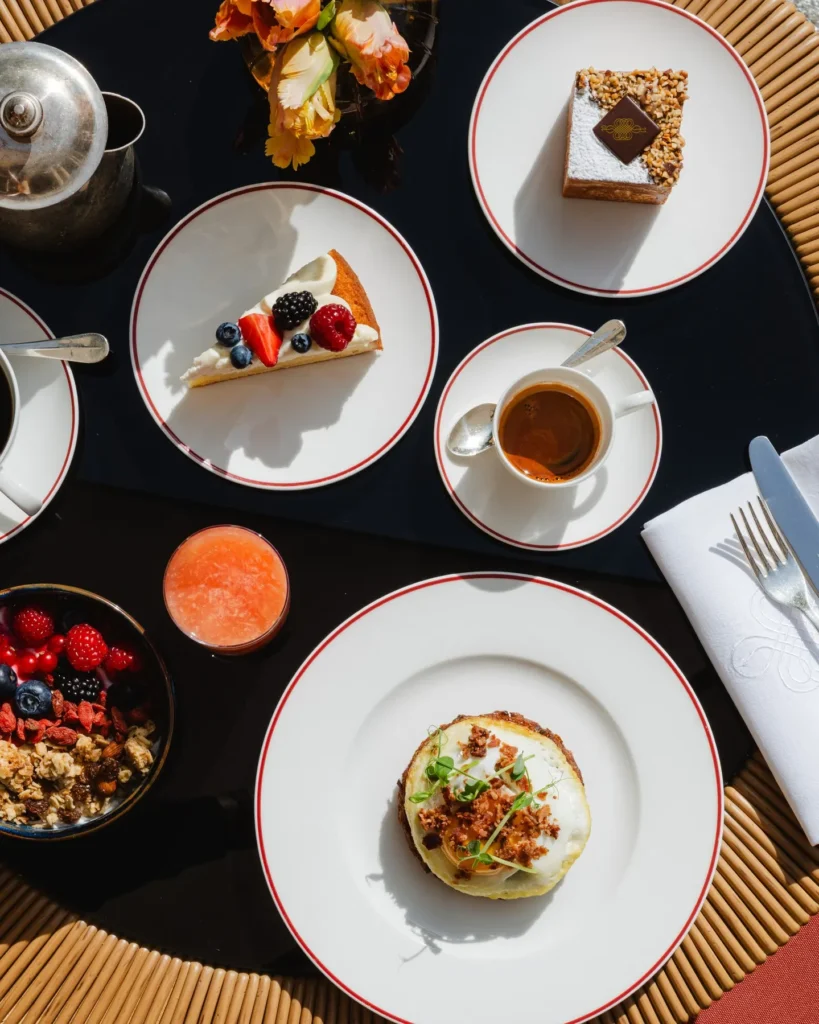 Overhead view of a gourmet tasting menu featuring colorful plated dishes and refined tableware at Portrait Milano